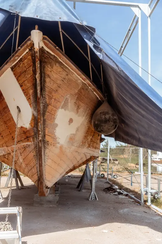 Bateau en bois à terre sur supports sous une bâche à Dettwiller